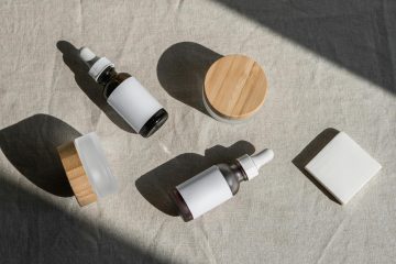 A minimalist flat lay of cosmetic bottles and jars on a linen cloth, perfect for beauty product presentations.