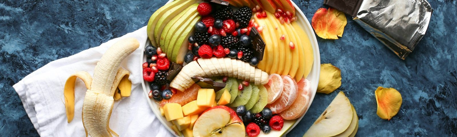 bowl of sliced fruits on white textile